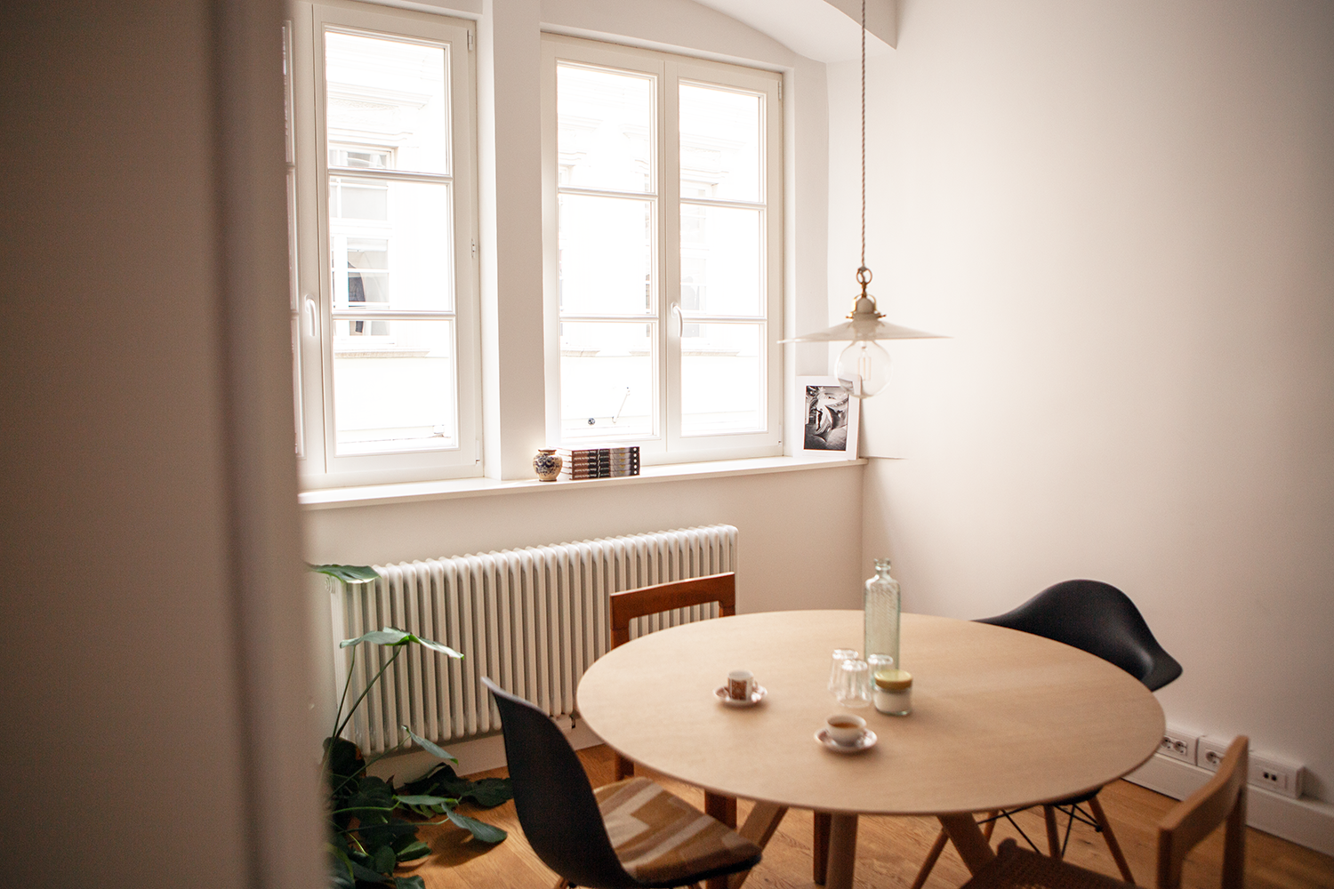 Ein Meetingraum in einem Altbaubüro. Runder Tisch mit 4 Stühlen und zwei Kaffeetassen auf dem Tisch