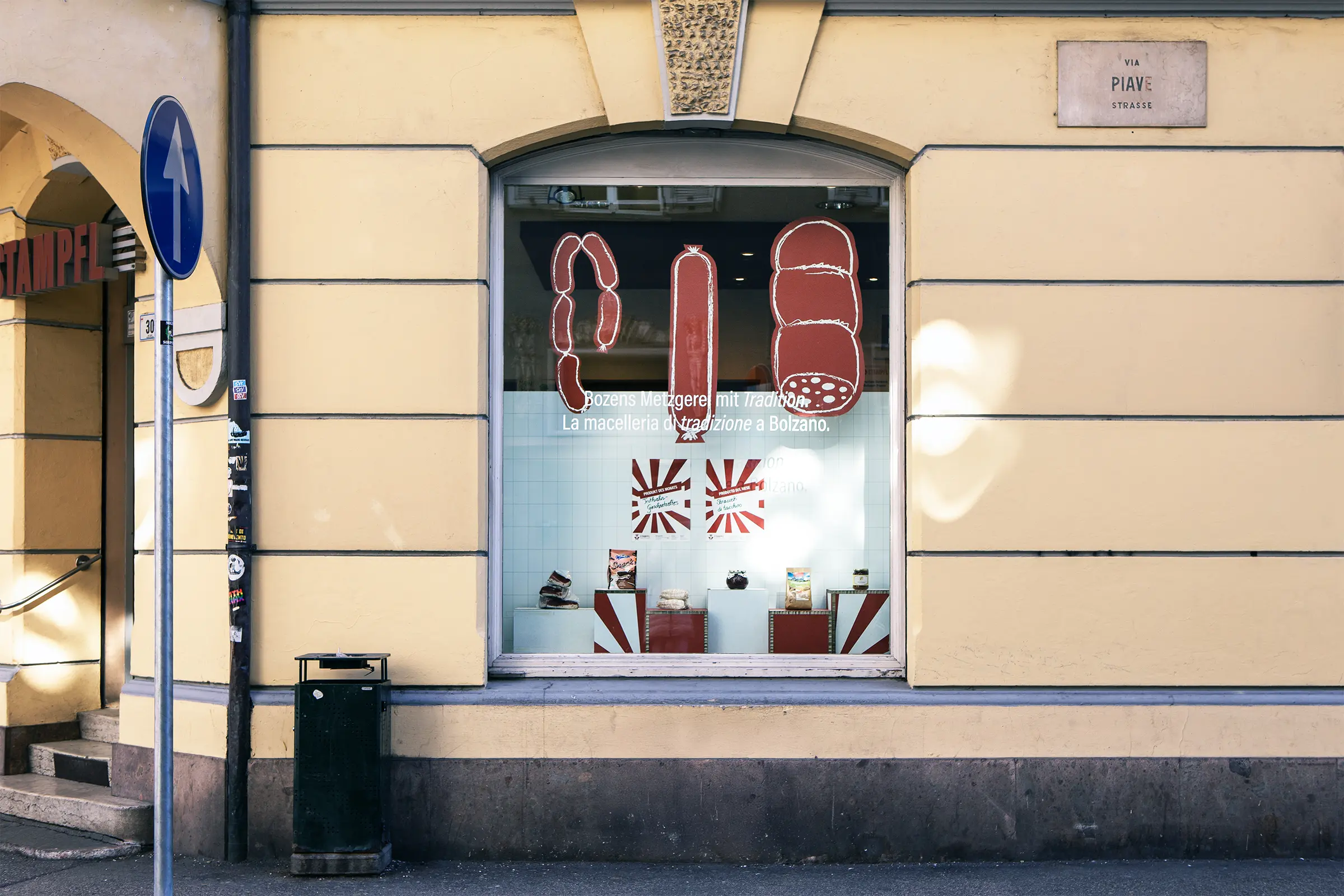 Schaufenster der Metzgerei Stampfl mit drei Wurstwaren aus Wabenkarton und 6 Podesten präsentieren Produkte