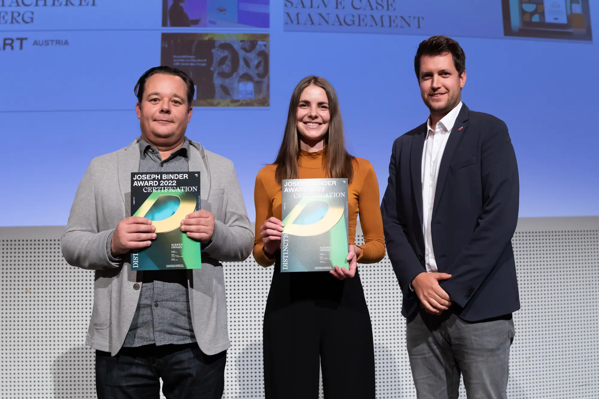 Franziska Heiß und Clemens Eichberger stehen auf der Bühne und nehmen den Joseph Binder Award 2022 für i-kiu design entgegen.