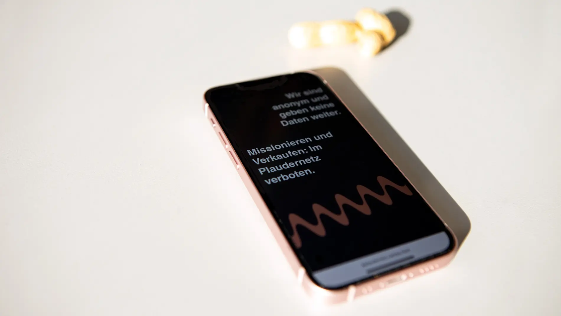 Ein Smartphone zeigt das mobile Webdesign für Plaudernetz mit Text-Elementen und einer Wellen-Illustration.