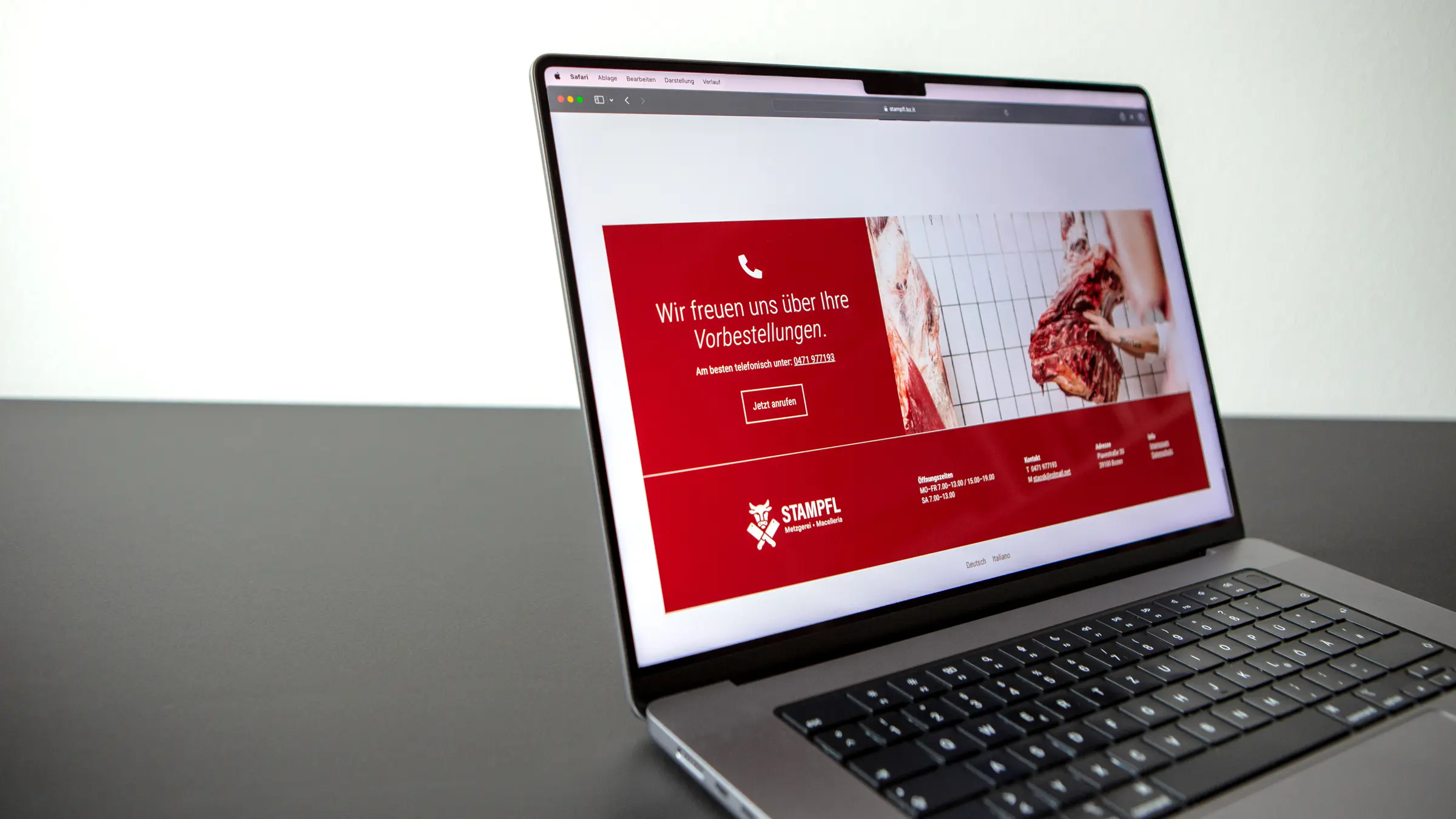 Laptop, der die Website der Metzgerei Stampfl anzeigt. Darauf ist ein Call-to-Action-Element und ein Foto von Fleischhälften zu sehen.