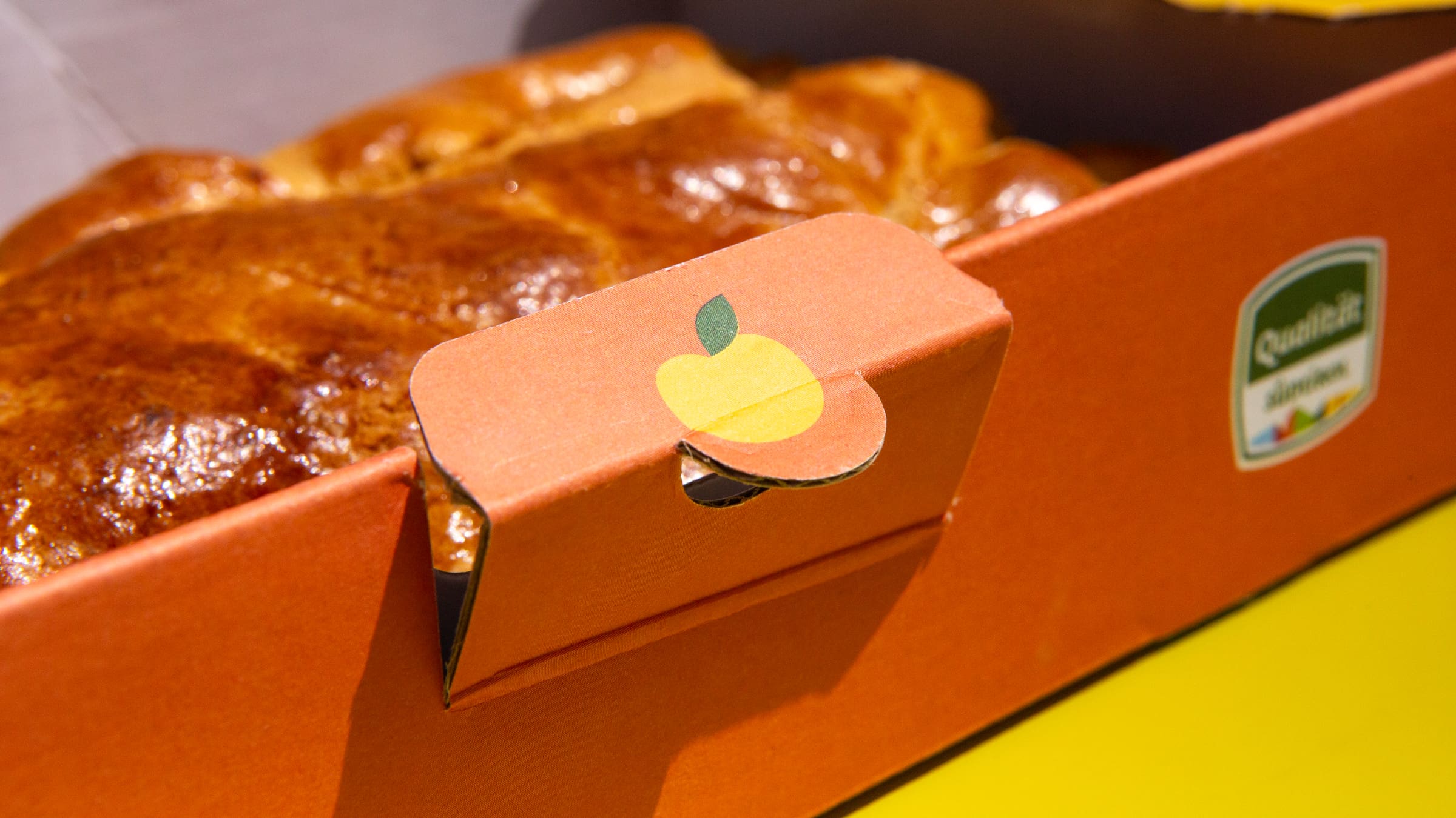 Verschluss-Lasche der Kartonverpackung für Südtiroler Apfelstrudel mit Apfel-Illustration.